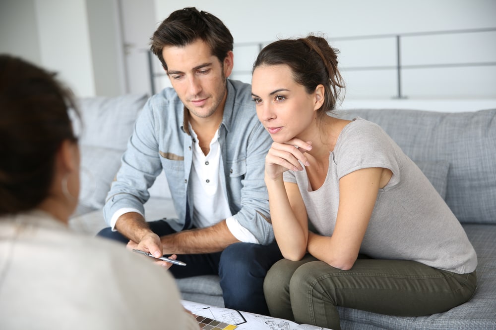 two house buyers asking the existing owner questions about the property